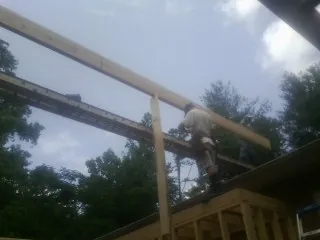 Carpenter setting a ridge beam over a new addition frame — Ice Dam Removal by Roofing Brothers in Cedaredge