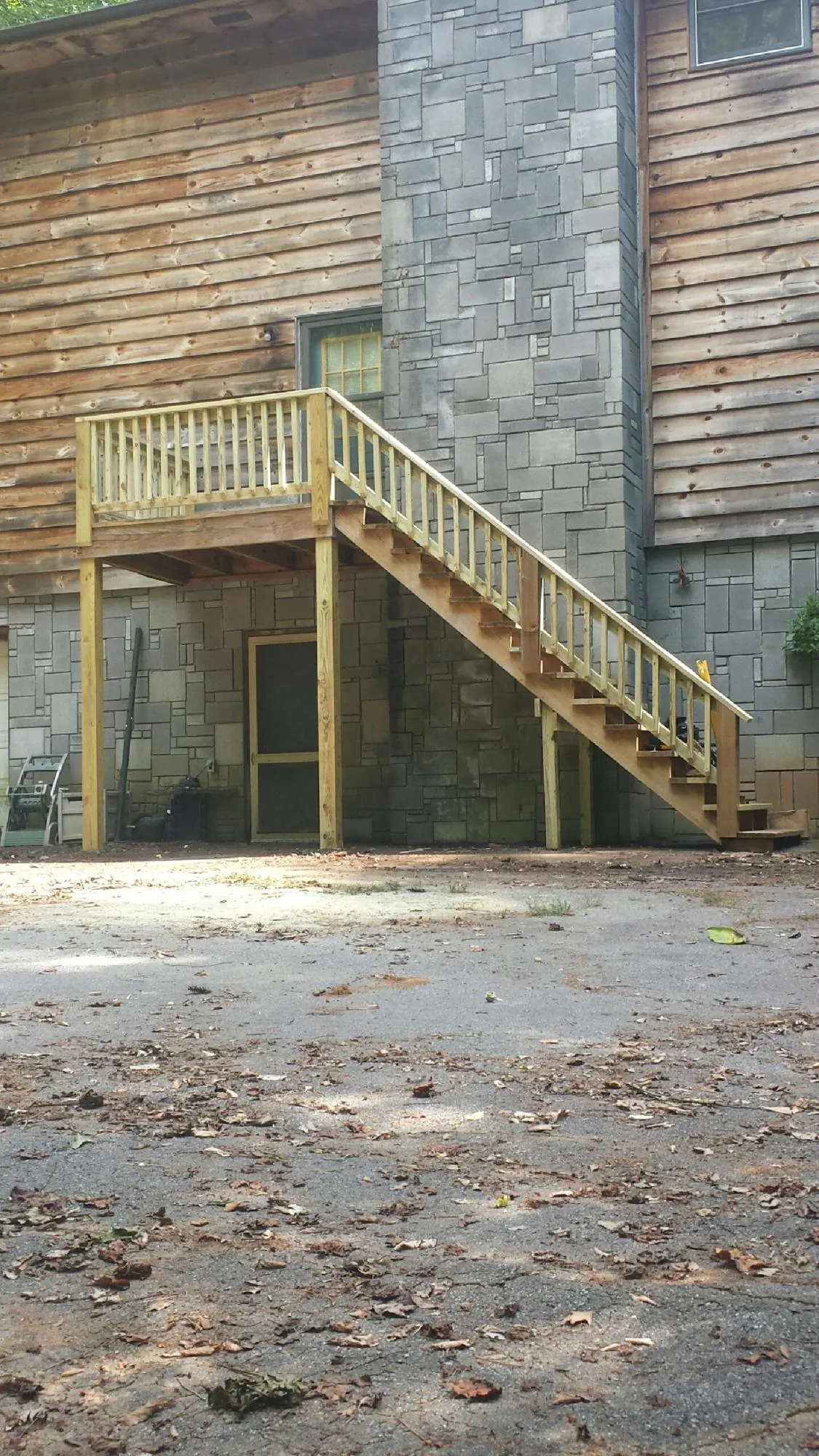New pressure treated deck and stair landing on a log home in Cedaredge